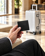 Black ALTAIR cardholder resting on an ALTAIR aluminium suitcase